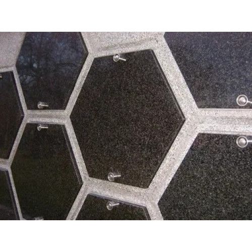 Die Urnenfachabdeckung aus Naturstein im Modell Hexagon zeigt eine multicolor Jasberg-Oberfläche mit sechseckiger Form und metallischen Befestigungen.