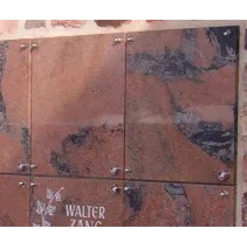 Die Urnenfachabdeckung aus Naturstein im Modell Quader zeigt eine multicolorierte Oberfläche in Jasberg-Optik mit vier quadratischen Platten und Metallbefestigungen.