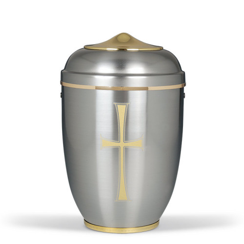 Stahlurne in polierter Messingoptik mit goldfarbenem Band und goldenem Kreuz, ovaler Form, Gesamtansicht.