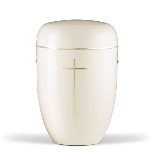 Die cremeweiße Naturstoffurne hat eine ovale Form, einen abgerundeten Deckel und ist mit einem goldenen Band sowie einem goldenen Kreuz verziert.