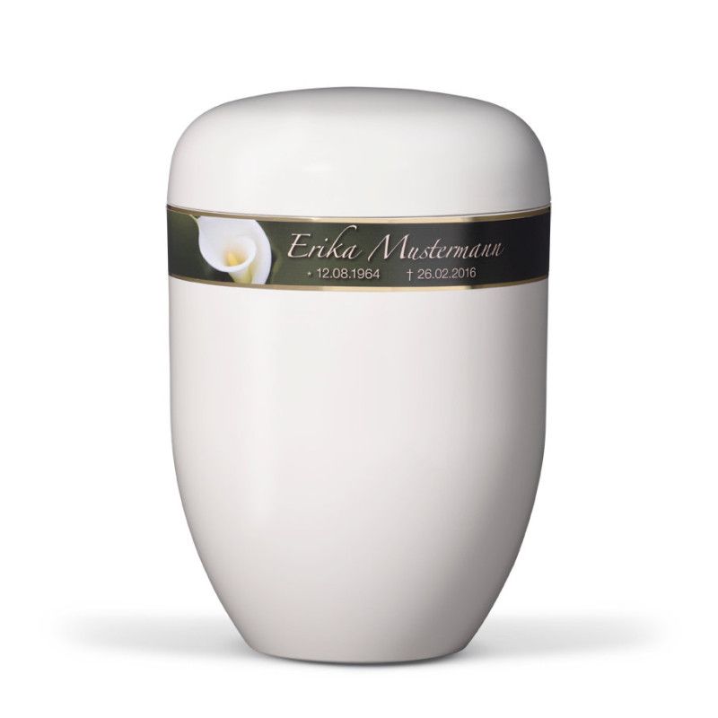 Die cremeweiße Naturstoffurne hat eine ovale Form und ist mit einem Dekorband in dunklem Grün mit einer Calla-Blume sowie persönlichen Sterbedaten versehen.