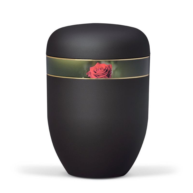 Die Naturstoffurne ist anthrazitfarben mit einem Velours-Dekorband, das eine Rosenblüte zeigt, und hat eine ovale Form mit einem leicht gewölbten Deckel.