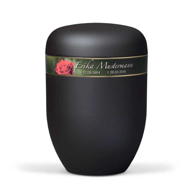 Naturstoffurne in anthrazit Velours mit einem dekorativen Band, das eine Rosenblüte und persönliche Sterbedaten zeigt, in Gesamtansicht.