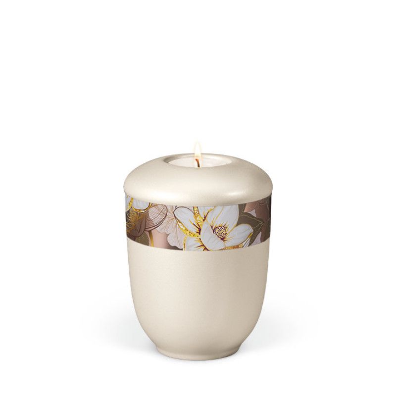 Cremeweiße Keramikurne mit perlmuttartiger Oberfläche, verziert mit einem rosé goldenen Dekor von Magnolienblüten und einem integrierten Teelicht.