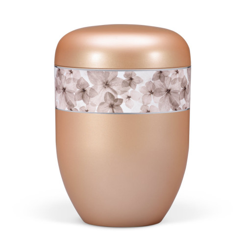 Die Naturstoffurne in Apricot hat eine ovale Form, eine matte Oberfläche und ist mit einem dekorativen Band aus blütenförmigem Design verziert.