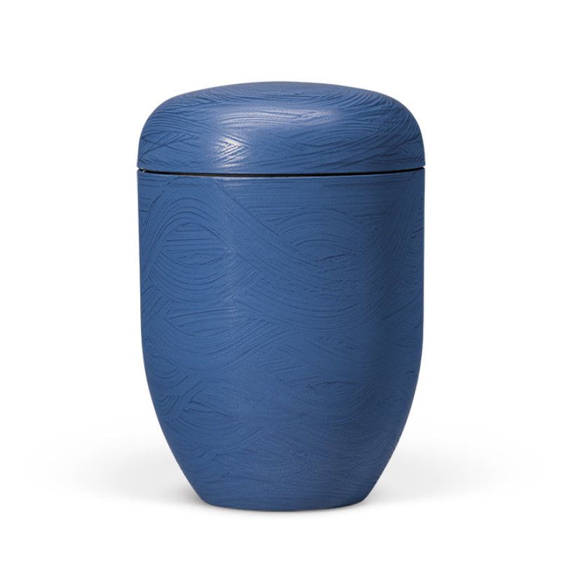 Naturstoffurne in Meeres-Blau mit einem Wellenmotiv, steinbeschichtet, in ovaler Form mit abgerundetem Deckel, Gesamtansicht.