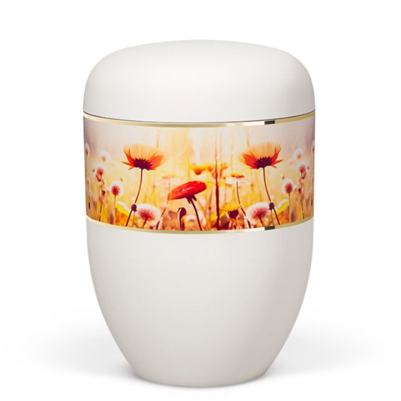 Die Naturstoffurne ist weiß matt, hat eine ovale Form und ein dekoratives, breites Band mit bunten Wildblumenmotiven sowie einem goldenen Rand.