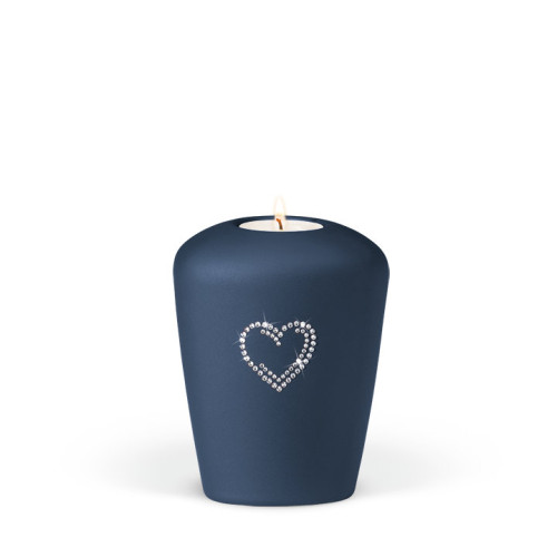 Keramikurne in Blau mit perlmuttartiger Oberfläche, Herzmotiv aus Kristallelementen, Gesamtansicht mit Teelicht in der Mitte.