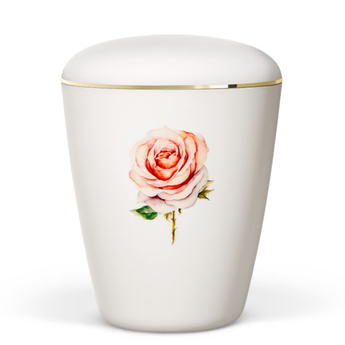 Die Naturstoffurne in Weiß-Matt hat eine ovale Form, ist mit einer goldenen Borte verziert und zeigt eine rosa Rose als Dekor.