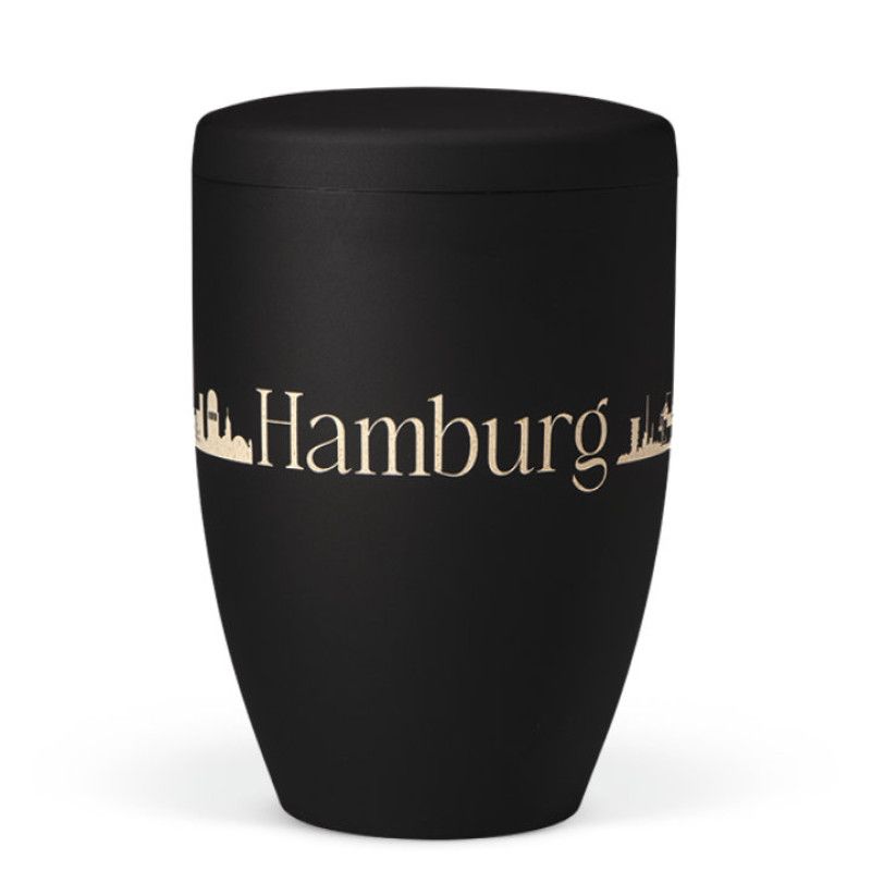 Naturstoffurne in anthrazitfarbenem Velours mit Lasergravur der Silhouette von Hamburg, in konischer Form und mit passendem Deckel.