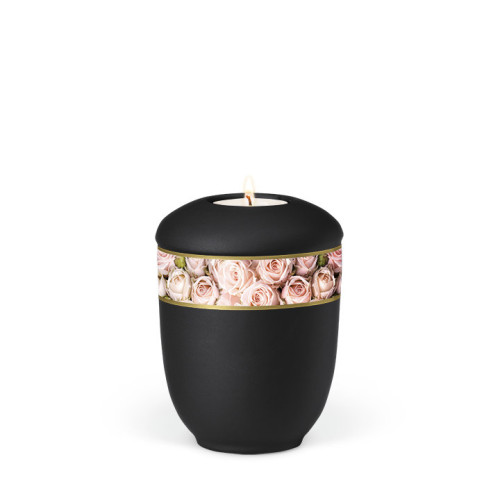 Die schwarze Keramikurne hat eine runde Form, ein dekoratives Band mit Rosenblättern in Rosa und ein Teelicht auf der Oberseite.