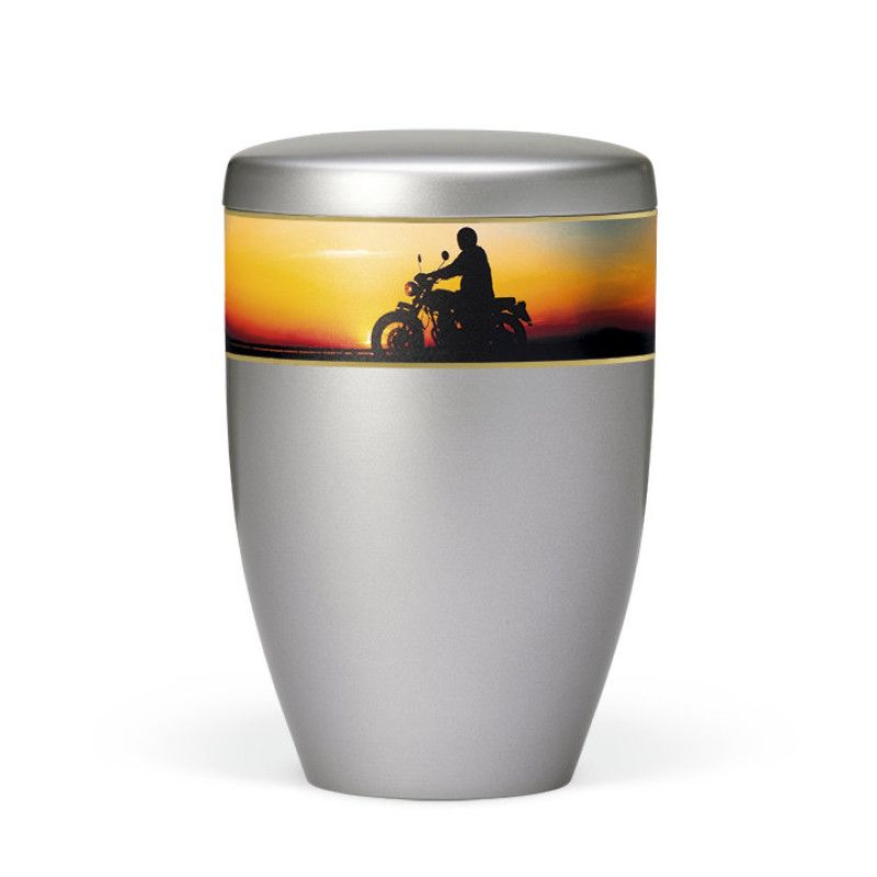 Naturstoffurne in Stahlgrau mit einem dekorativen Band, das einen Motorradfahrer vor einem Sonnenuntergang zeigt, Gesamtansicht.