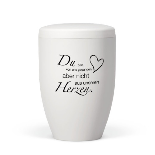 Die weiße, matte Naturstoffurne hat eine ovale Form und zeigt einen Trauertext in schwarzer Schrift, ergänzt durch ein Herzsymbol.