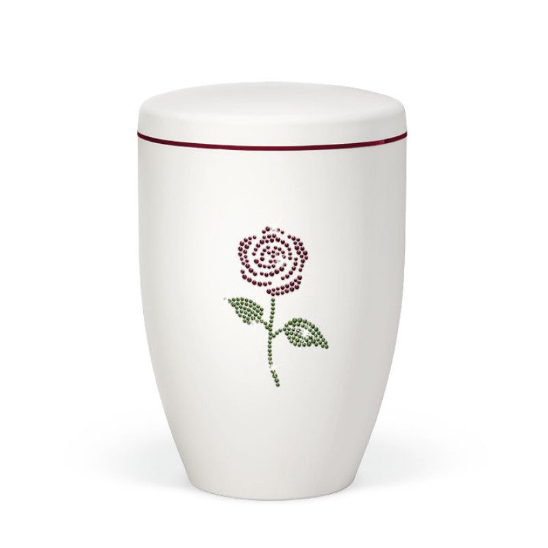 Naturstoffurne in Weiß-Matt mit einem dekorativen Rosenmotiv aus farblichen Crystal Elements und einem roten Dekorband am Deckel.