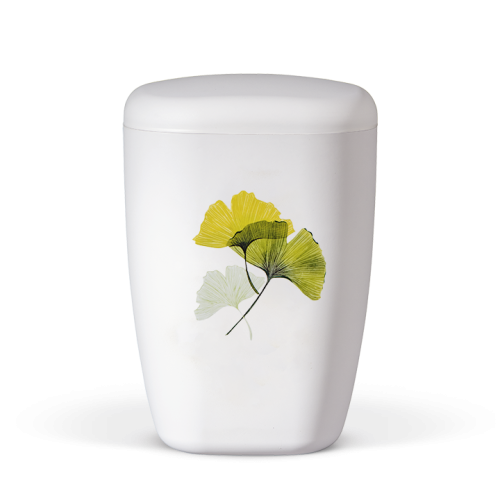 Die Naturstoffurne in Weiß Matt hat eine ovale Form und zeigt ein dekoratives Motiv von Ginkgo-Blättern in Gelb und Grün auf der Vorderseite.