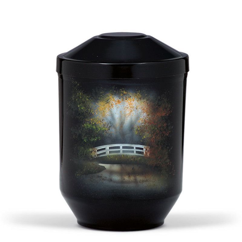 Die schwarze Stahlurne mit Airbrush-Dekor zeigt eine idyllische Landschaft mit einem weißen Brückenmotiv und bunten Herbstbäumen in einer Gesamtansicht.