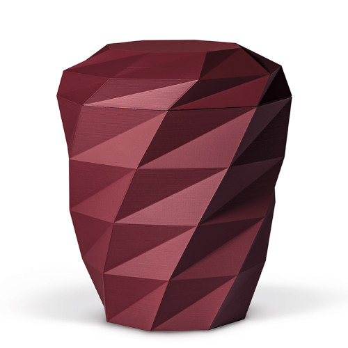Die naturstoffurne in weinrot aus Velours hat eine facettierte, geometrische Form und ist in einer Gesamtansicht dargestellt.