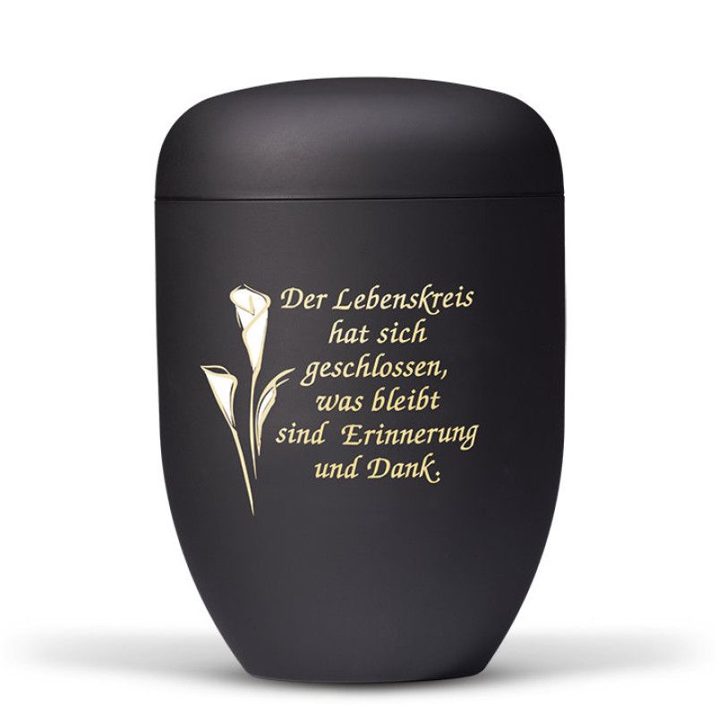 Die anthrazitfarbene Stahlurne hat eine runde Form, ist mit einem Velours-Finish versehen und zeigt ein gold-weißes Foliendekor mit Calla und Trauertext.