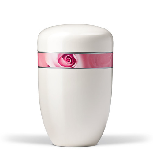 Die cremeweiße Stahlurne hat eine ovale Form und ist mit einem dekorativen Band in Rosa mit Rosenblüten-Motiv verziert.