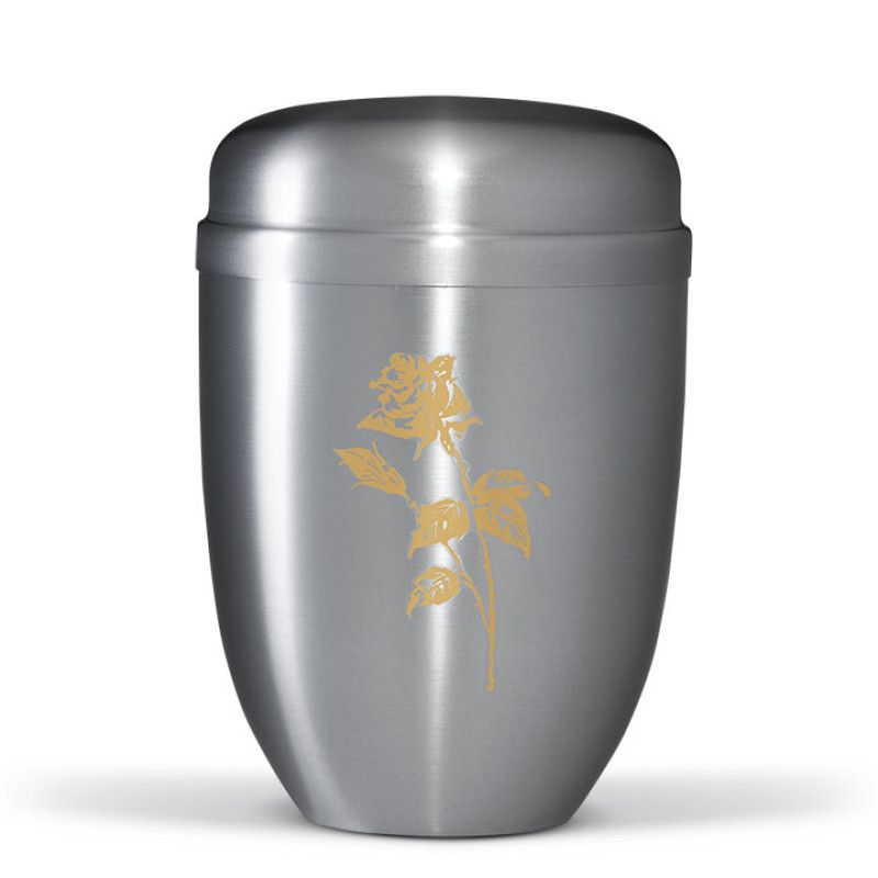 Die Stahlurne ZIHESTA ist silberfarben mit einer goldenen Rose als Dekor, hat eine runde Form und zeigt eine Gesamtansicht.