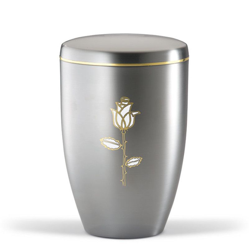 Die Stahlurne ZIHESTA hat eine glänzende, silberne Oberfläche mit einem goldenen Band und einer aufgedruckten Rose in Weiß und Gold, in Gesamtansicht.