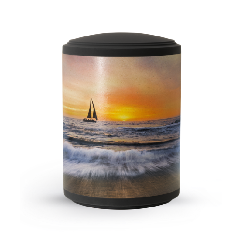 Urne aus Samton in schwarz mit einem bunten Motiv eines Segelboots vor einem Sonnenuntergang, Gesamtansicht mit glatter Oberfläche.