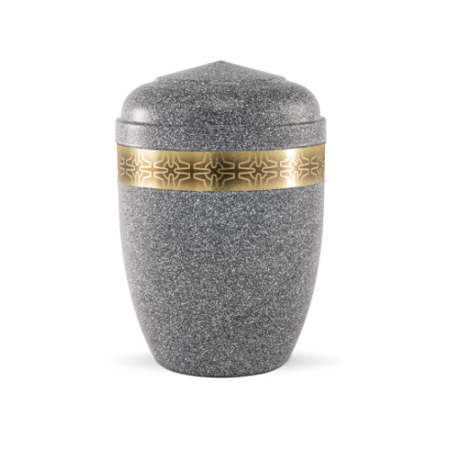 Die Urne aus basaltfarbenem Stahl hat eine ovale Form, einen flachen Deckel und ist mit einem goldenen Messingzierband mit Kreuzmuster verziert.