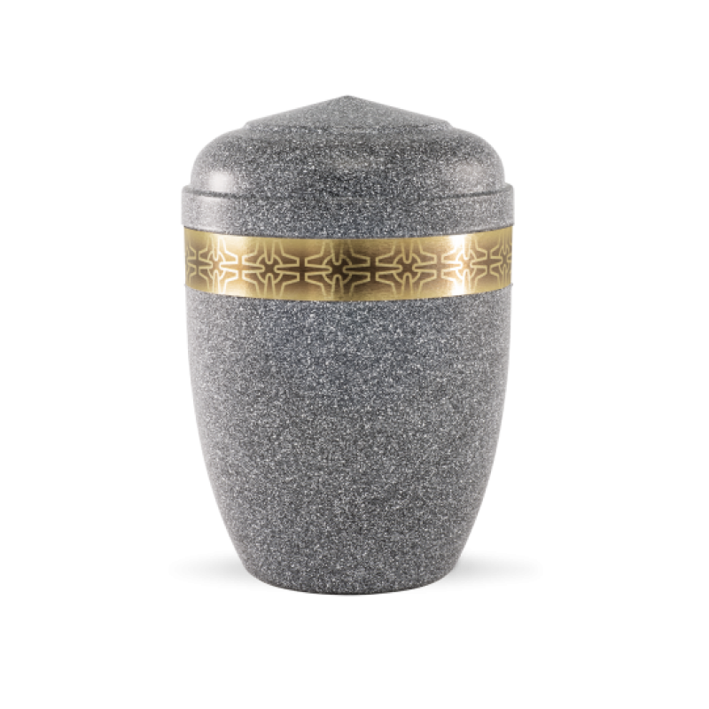 Die Urne aus basaltfarbenem Stahl hat eine ovale Form, einen flachen Deckel und ist mit einem goldenen Messingzierband mit Kreuzmuster verziert.