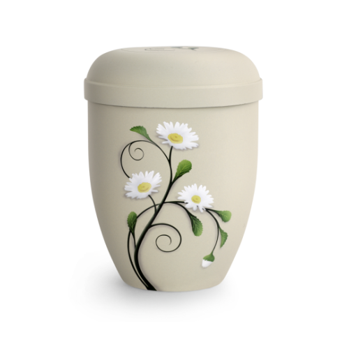 Die cremefarbene Urne aus der Edition Classic ist aus bioloisch abbaubarem Material gefertigt und zeigt eine dekorative Margeritenmotivation auf der Vorderseite.