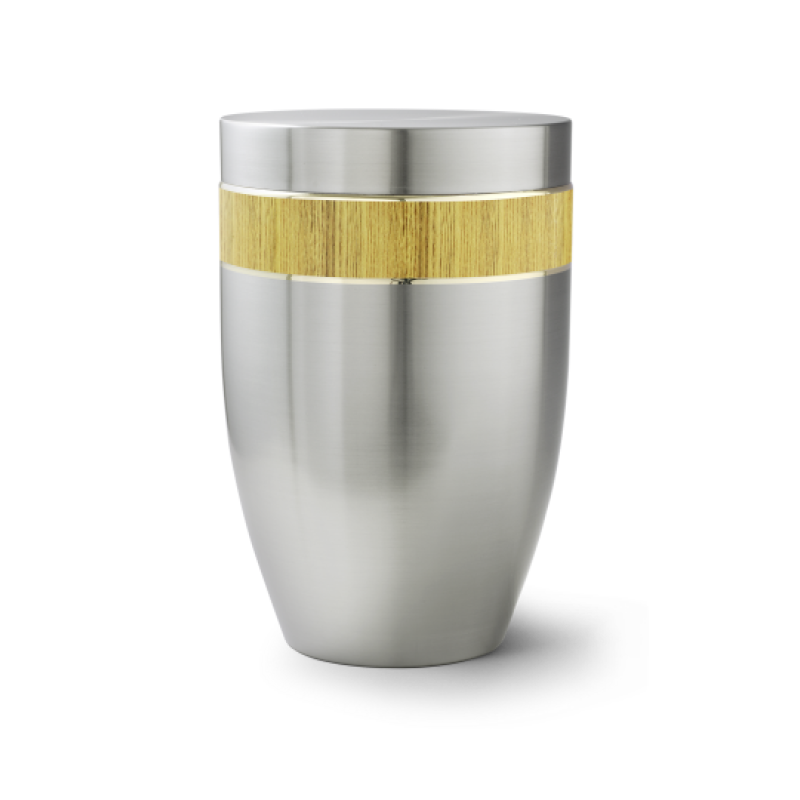 Die Urne der Edition Melina ist gebürstet, hat eine silberne Metalloberfläche und einen dekorativen, goldfarbenen Streifen aus Cestal.