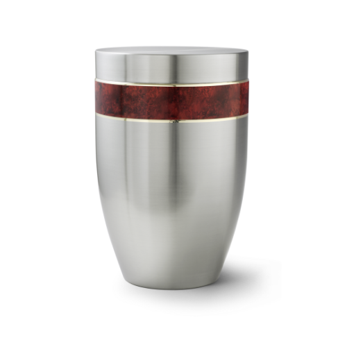 Die Urne der Edition Melina ist aus gebürstetem Edelstahl gefertigt, hat eine ovale Form und eine dekorative rotbraune Wurzelholz-Einlage mit goldfarbener Linie.