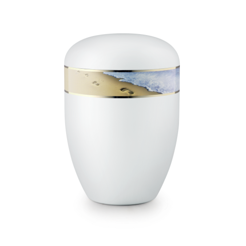 Die Urne ist weiß satiniert, hat eine ovale Form und zeigt eine goldene Bandverzierung mit Fußspuren im Sand und Wellenmotiv.