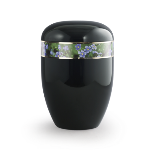 Die Urne in Klavierlack schwarz hat eine ovale Form, eine dekorative Banderole mit blauen Vergissmeinnicht-Blüten und ist biologisch abbaubar.