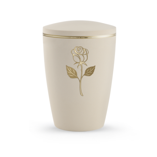 Die Urne in Samtton Creme hat eine ovale Form, ist aus biologisch abbaubarem Material gefertigt und zeigt eine goldene Rose mit Blättern auf der Vorderseite.