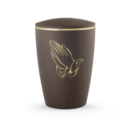 Die Urne aus der Edition Melina in Samtton Cafe hat eine ovale Form, ist aus biologisch abbaubarem Material gefertigt und zeigt betende Hände in goldener Farbe.