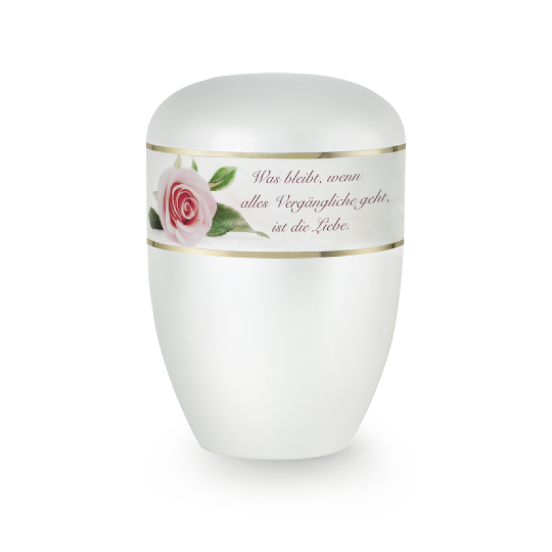 Die Urne in Perlmuttfarbe hat eine runde Form, einen glatten Deckel und ist mit einem Aufkleber mit einer Rose und dem Spruch "Was bleibt, wenn alles Vergängliche geht, ist die Liebe" verziert.