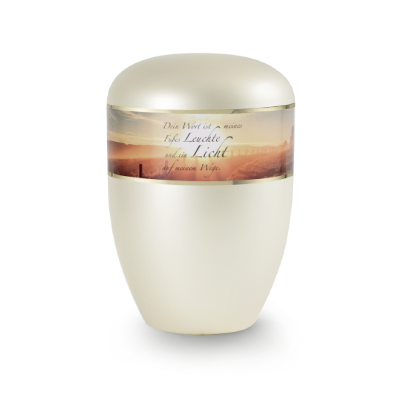 Die Urne in perlmutt champagner hat eine ovale Form, einen glatten, glänzenden Körper und einen dekorativen Aufkleber mit einem Sonnenaufgang und dem Text „Dein Wort ist meines Fußes…“.