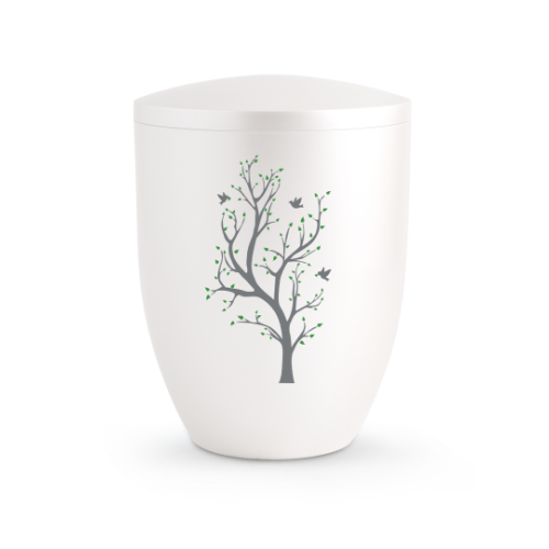 Die Urne der Edition Silva ist perlmuttfarben, hat eine runde Form und zeigt einen grauen Baum mit grünen Blättern und Vögeln auf der Vorderseite.