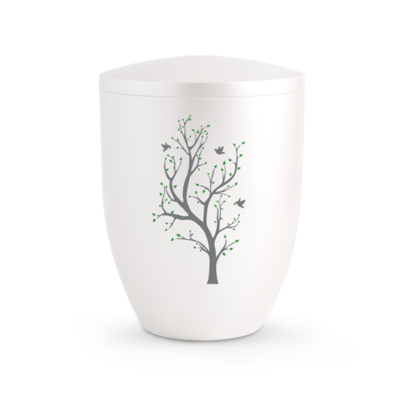 Die Urne der Edition Silva ist perlmuttfarben, hat eine runde Form und zeigt einen grauen Baum mit grünen Blättern und Vögeln auf der Vorderseite.