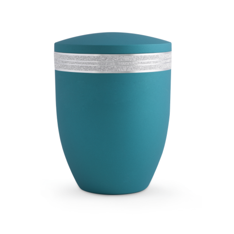 Die Urne der Edition Krypta in Samton Arctic-Türkis hat eine matte Oberfläche, ist oben abgerundet und mit einem glitzernden, mattsilbernen Dekor eingefasst.