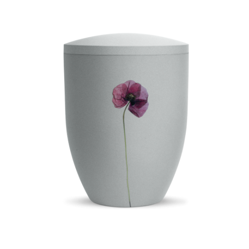 Die Urne in Samtton Grau hat eine ovale Form, einen abnehmbaren Deckel und ist mit einer Mohnblume verziert, sie ist biologisch abbaubar.