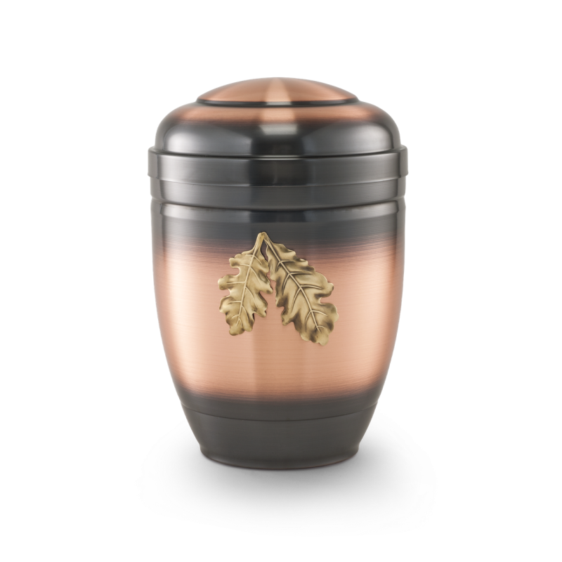 Eine ovale Urne aus galvanisch gefärbtem Kupfer mit einer schwarzen Oberfläche und zwei goldenen Eichenblättern als dekoratives Element.