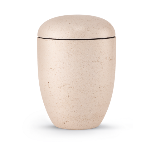 Die Terra-Jura Urne Edition Rocka ist cremefarben, hat eine geschliffene Steinoptik und eine ovale Form mit einem abgerundeten Deckel.