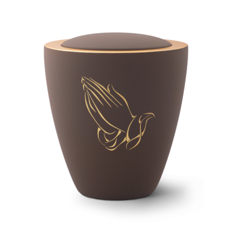 Die Urne aus der Edition Colour Line in Samton café ist aus Keramik, hat eine konische Form und zeigt goldene, betende Hände auf der matten Oberfläche.