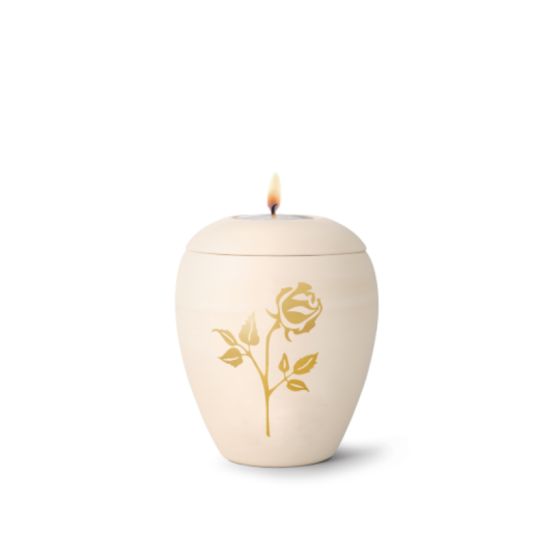 Gedenklicht aus cremefarbener Keramik in Form einer Urne mit handbemalter goldener Rose, Gesamtansicht mit brennendem Docht.