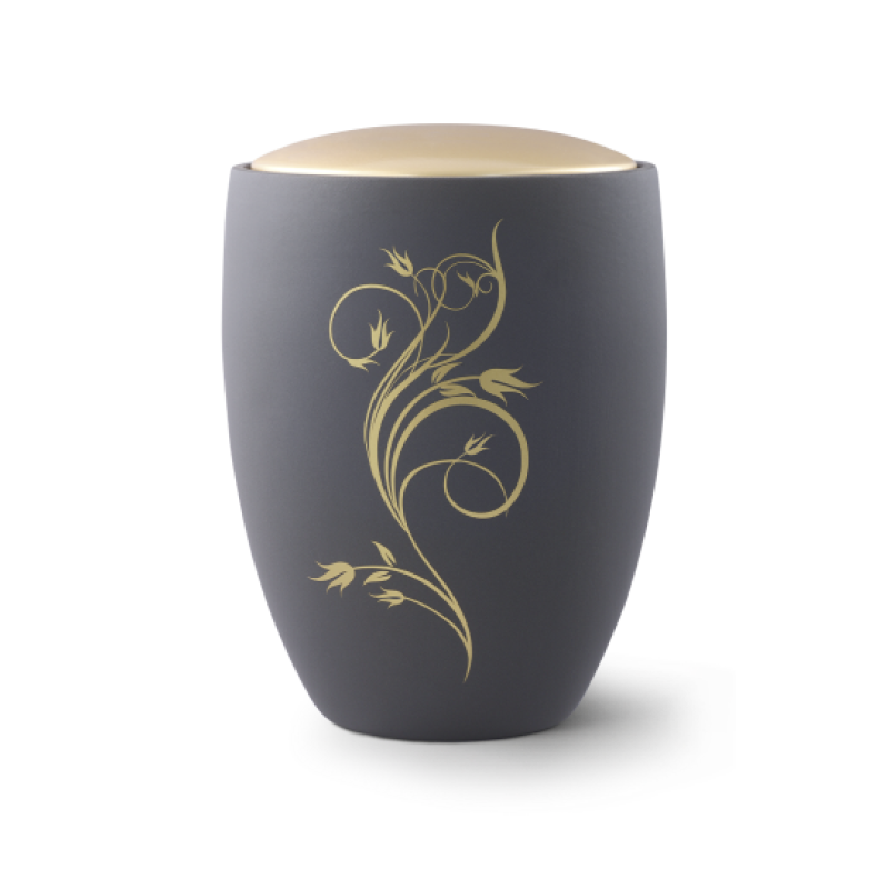 Die Urne aus der Edition Remember Me ist aus graphitfarbener Keramik, hat eine ovale Form und zeigt ein florales Ornament in Gold auf der Vorderseite.