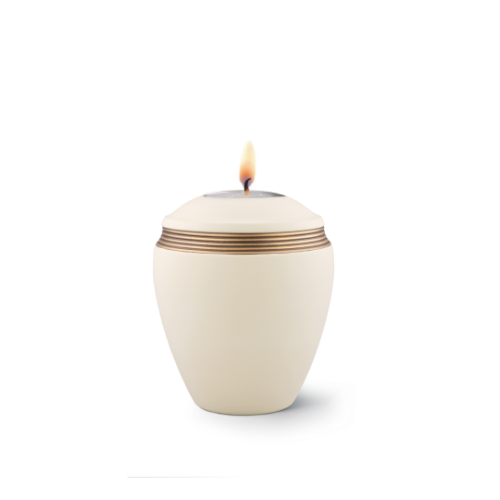 Gedenklicht in Samtton creme aus Keramik mit handbemaltem Dekor in altgold, ovaler Form und brennender Flamme auf der Oberseite, Gesamtansicht.