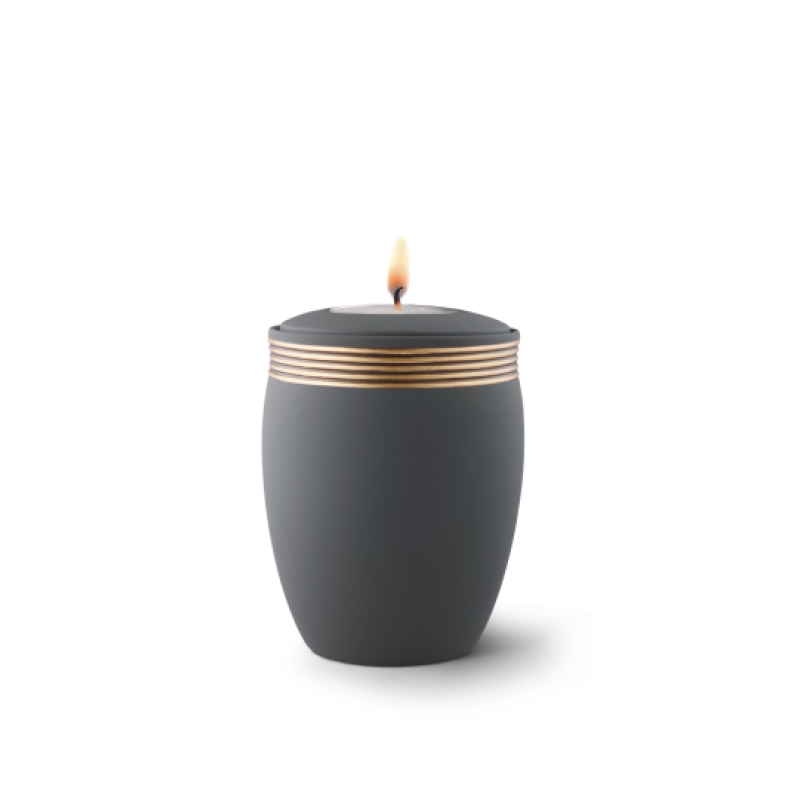 Gedenklicht aus Keramik in Samtton graphit mit handbemaltem Dekor in altgold, ovaler Form und brennender Flamme auf der Oberseite.