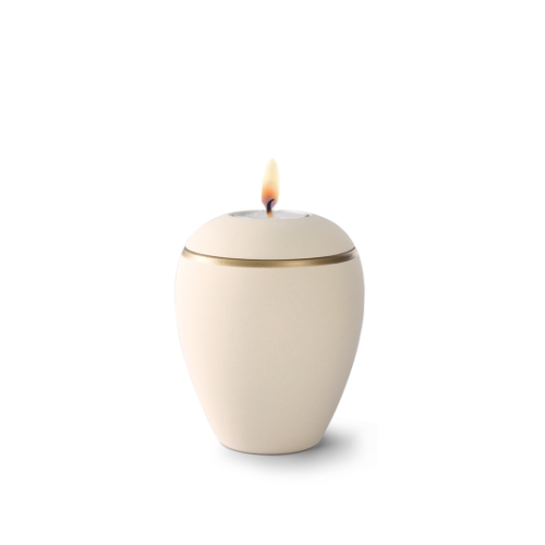 Gedenklicht aus Keramik in Samtton creme mit altgold Dekorstreifen, in Eiform mit brennender Kerze auf der Oberseite, Gesamtansicht.