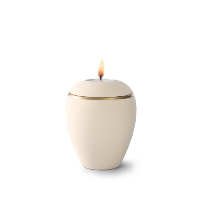 Gedenklicht aus Keramik in Samtton creme mit altgold Dekorstreifen, in Eiform mit brennender Kerze auf der Oberseite, Gesamtansicht.